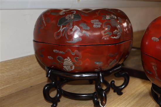A pair of Chinese red lacquer melon form lidded boxes, on hardwood stands, height 30cm